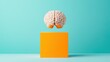 © JK_kyoto - Brain Model Above Orange Cube on Teal Background in Creative Concept