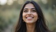 © AKSNA - Close Up Portrait of a Young Indian Woman in Professional Suit with Radiant Smile and Warm Expression on Light Blue Background