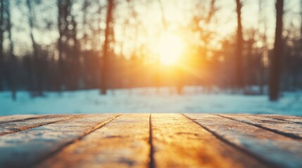 Wall Mural - Wooden table in a serene winter forest, surrounded by snow and trees, as the sun sets and bathes the landscape in warm light