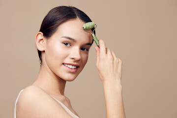 young woman using a facial roller for skincare, promoting healthy beauty and wellness routines in a 