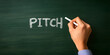 © A2Z AI  - Hand writing the word 'Pitch' in chalk on a dark green chalkboard.  Concept of ideas, presentations, and marketing.