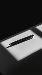 Wall Mural - a black pen is sitting on a table. the pen is black and has a gold tip. the pen is laying on a white