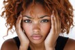 © Art - A woman with curly hair displays a concerned expression while holding her face in her hands.
