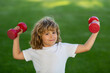 © Volodymyr - Child boy pumping up biceps muscles with dumbbell. Summer sport. Fitness kids with dumbbells.