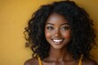 © Ciburia - A smiling young woman with curly hair against a vibrant yellow background.