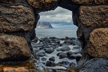 Wall Mural - a glimpse into the ocean through a natural opening in a rocky outcropping