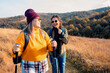 © Zoran Zeremski - Two smiling woman hiking at top of the hill at meadow.
