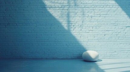 Wall Mural - Minimalist interior with light blue brick wall and white abstract object casting shadows with ample copy space