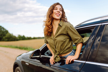 Wall Mural - Young woman travelling by car or camper van, open window breathe fresh air of countryside. Travel adventure drive.