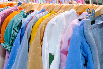 Poster - A rack of clothes with a green shirt and a white shirt. The green shirt has a star on it