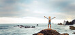 © Davide Angelini - Man with backpack raising arms up at the beach - Traveler male enjoying freedom on summer vacation - Successful hiker celebrating victory on the top of the mountain