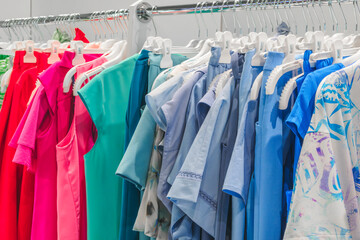 Poster - A rack of clothes with a green shirt and a white shirt. The green shirt has a star on it