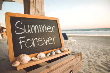 summer forever written on chalkboard at the beach during sunset