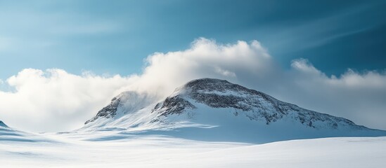 snow-capped mountain partially obscured by fluffy cloud under a vibrant aurora-lit sky with clear bl