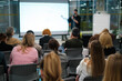 © Anton Gvozdikov - Business presentation with diverse audience in office setting, focusing on learning and networking within a corporate environment.