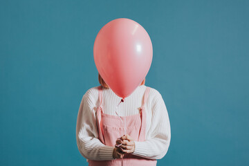 Wall Mural - Woman holding a pink balloon