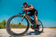 © Hip.hub - Cyclist navigating a gravel path near wind turbines under a clear blue sky