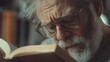 © Oleg - An older gentleman deeply engrossed in reading a book.