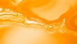 © avissarahmanita - Close-up view of a silky smooth orange liquid with subtle waves and ripples, creating an abstract background texture ideal for cosmetic and beauty product advertising.  The vibrant color and glistenin