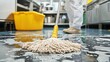© Cambo27 - A professional cleaner uses a mop to clean the kitchen floor, removing any dirt and spills after cooking