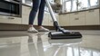 © Cambo27 - A family member vacuums the kitchen floor, ensuring that crumbs and debris are cleaned up after dinner