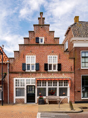 Wall Mural - Historic brick house with stepped gable in Kerkstraat in old town of Makkum, Friesland, Netherlands