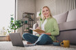 © deagreez - Young woman enjoying a cozy day at home journaling while sitting on the floor in a beautifully decorated living room.