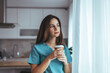© Dragana Gordic - Thoughtful Nurse Relaxing With Coffee at Home Near Window