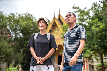 Local Asian tour guide explaining temple history to Asian female tourist