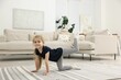 © New Africa - Little girl exercising on rug at home. Sport activity