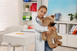 © New Africa - Girl with stethoscope and toy pretending to be doctor indoors