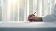 © OZTOCOOL - Close-Up of a Person's Hand Holding a Pen Over Blank Paper with Natural Light Illuminating a Soft Background of Sheer Curtains