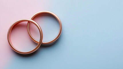 Close-up top view of two elegant wedding rings on a soft pastel color background with ample space for copy, symbolizing love, commitment, and romance, modern and dreamy engagement rings captured with 