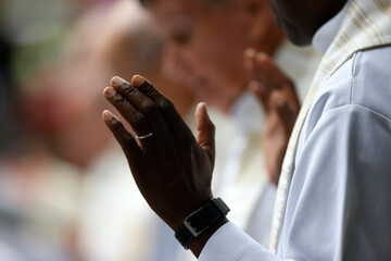 Wall Mural - Catholic mass. Lord's Prayer. Priest praying. Close-up on hands.  La Roche sur Foron..  France.