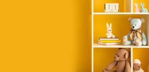 Wall Mural - Bookshelf with baby toys near yellow wall. Banner for design