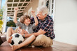 © Marko Geber - Grandfather and grandson playing with soccer ball on the porch