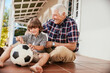 © Marko Geber - Grandfather and grandson playing with soccer ball on the porch