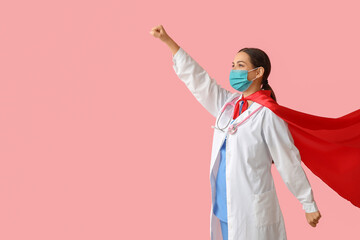 Poster - Beautiful female doctor in superhero costume and medical mask on pink background