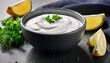 © Lura - dark grey ceramic bowl of fresh sour cream dip sauce with herbs