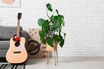 Wall Mural - Modern acoustic guitar with headphones near grey armchair in stylish living room