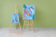 © Pixel-Shot - Paintings on easels near green wall