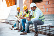 © Dragana Gordic - Team of Construction Workers Reviewing Plans at Site
