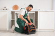 © Pixel-Shot - Male plumber with tool bag near sink in kitchen