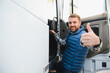 © Serhii - Truck driver climbing into the cab of a semi-truck on bright sunny day