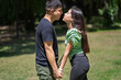 © Mariano - Latin couple holding hands about to kiss in a park under a vibrant sun