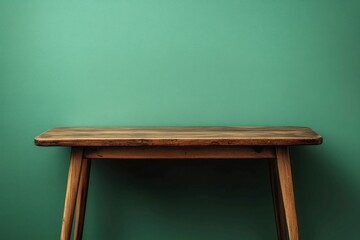 Wall Mural - a simple wooden table against a dark green wall with soft natural light creating shadows and a tranquil atmosphere