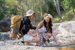 © Natee Meepian - LGBT couple enjoying a hiking adventure by a serene stream in nature