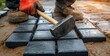 © app - laborer installing paving stones for patio construction with hammer closeup