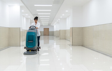 Woman using scrubber machine wash the floor