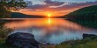 © Levan - Serene sunset over a tranquil lake surrounded by lush green hills featuring vibrant orange and purple hues reflecting on the water's surface.